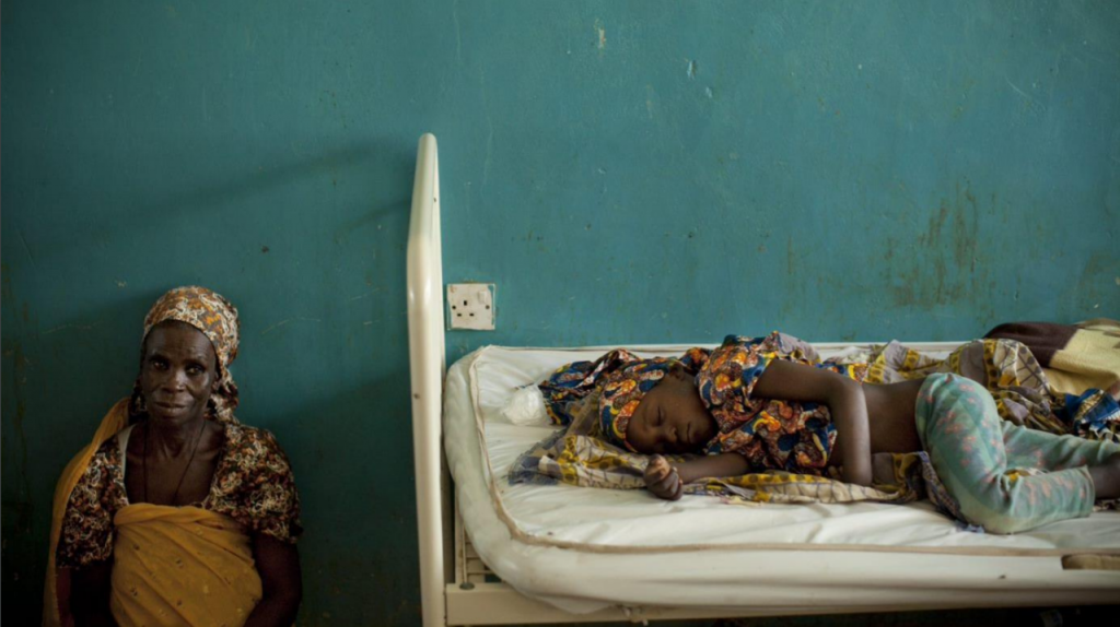 girl suffering from malaria, lying on a hospital bed